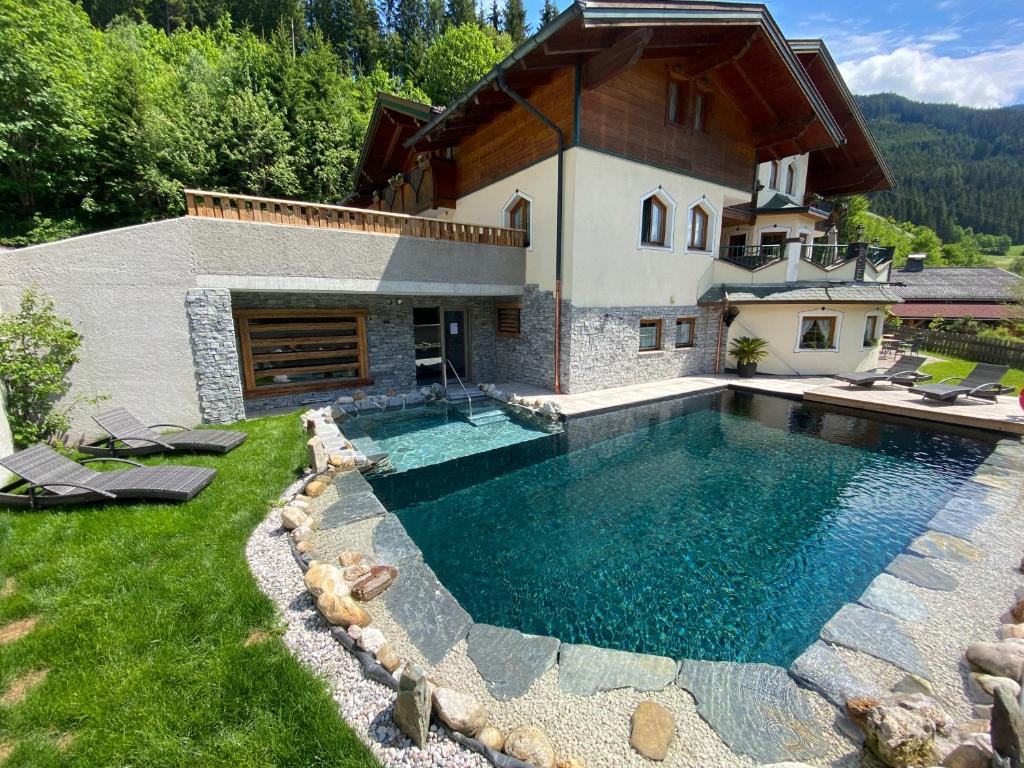 a house with a swimming pool in the yard at Das Geierberg in Filzmoos