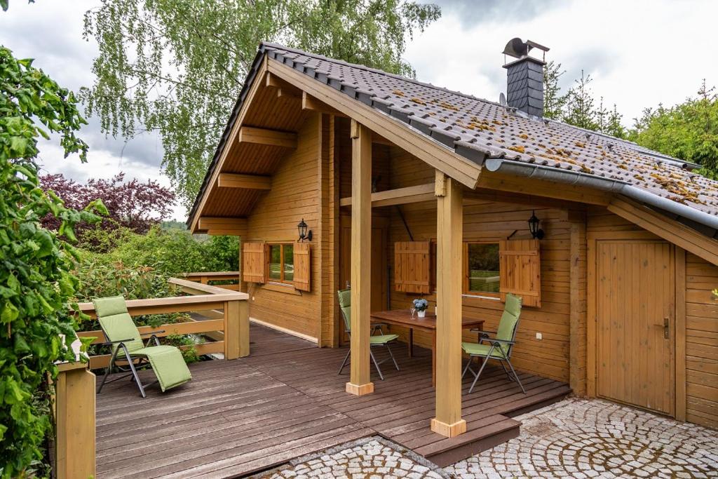 een houten hut met een tafel en stoelen op een terras bij Ferienhaus Weitblick Altenbrak in Altenbrak