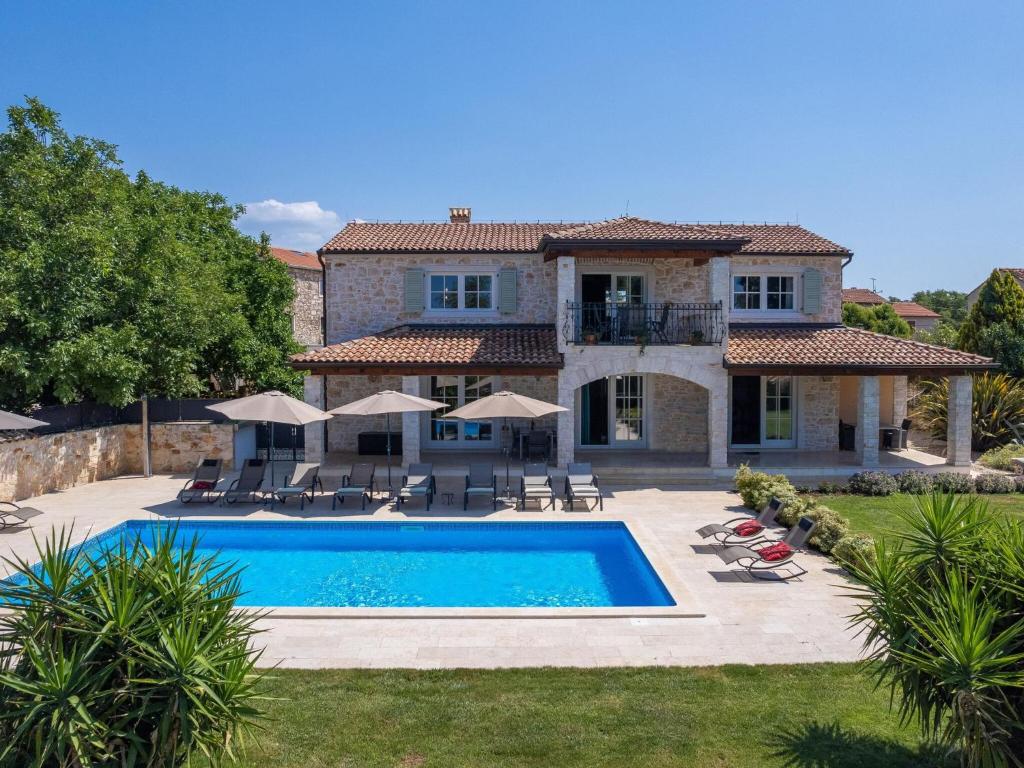 a house with a swimming pool in front of it at Picturesque Villa in Verteneglio with Pool in Brtonigla