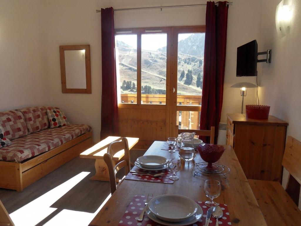 un salon avec une table et un canapé dans l'établissement Appartement cosy avec mezzanine proche des pistes, balcon, WIFI, animaux admis - FR-1-181-2067, à La Plagne Tarentaise