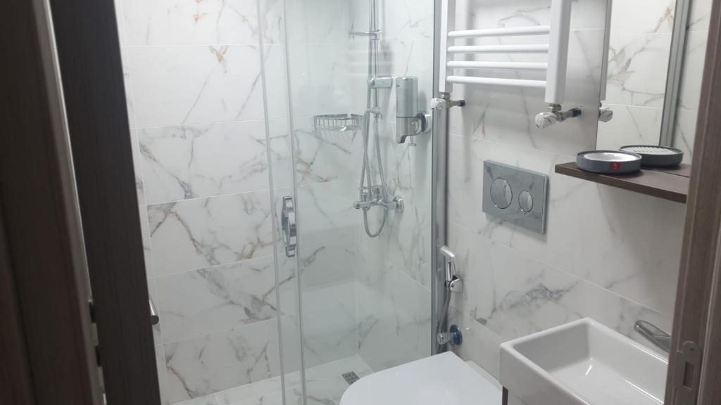 a bathroom with a shower with a toilet and a sink at NOOR FAMILY APARTMENTS in Bursa