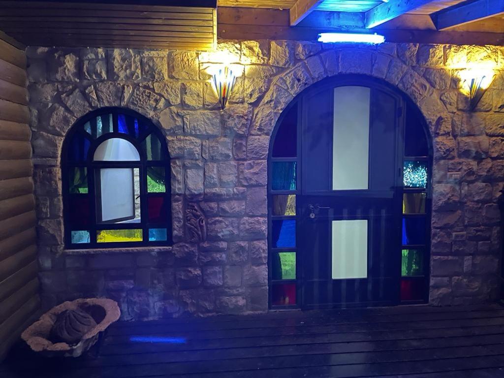 twee glas-in-loodramen in een kamer met een trap bij צימר מאיה in Ani'am