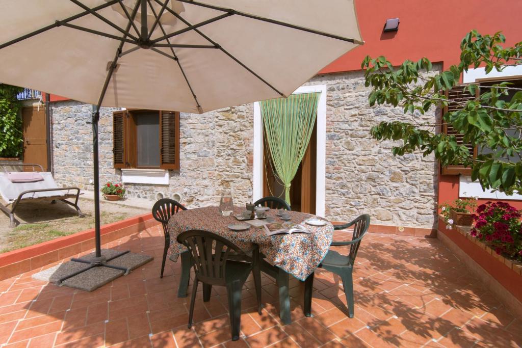 - une table et des chaises avec un parasol sur la terrasse dans l'établissement Costiera del Cilento Apartments, à Casal Velino