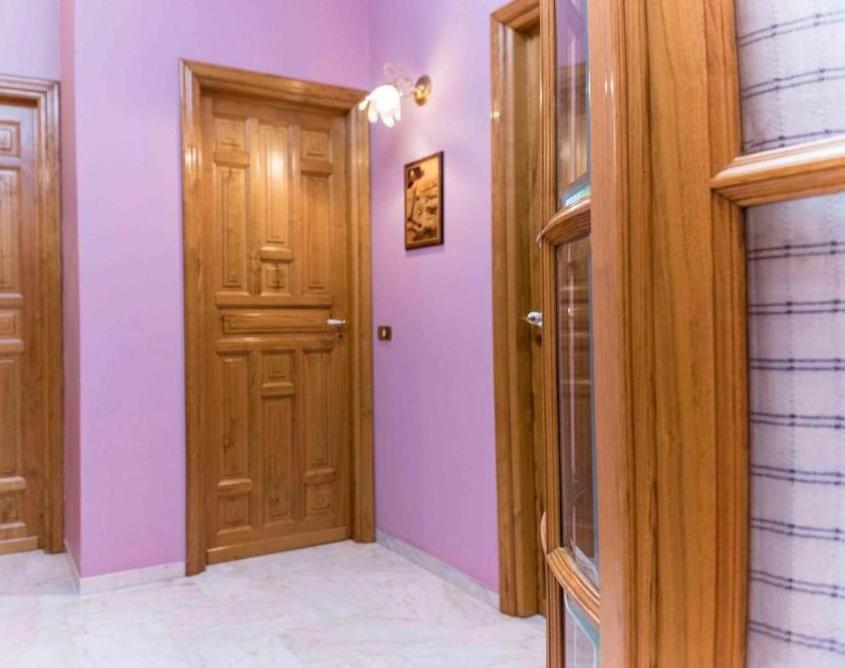 een hal met twee houten deuren en paarse muren bij Casa Mare e Monti Castelbuono in Castelbuono