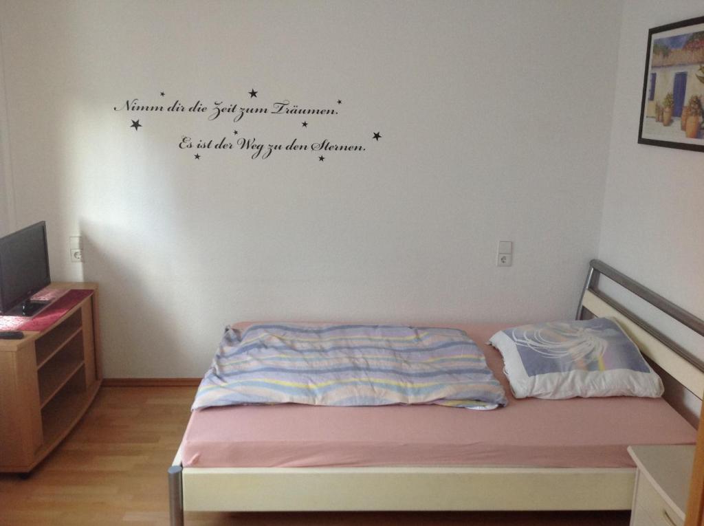 a bedroom with a bed with words on the wall at Ruhige Wohnung in Schnaitheim bei Heidenheim in Heidenheim