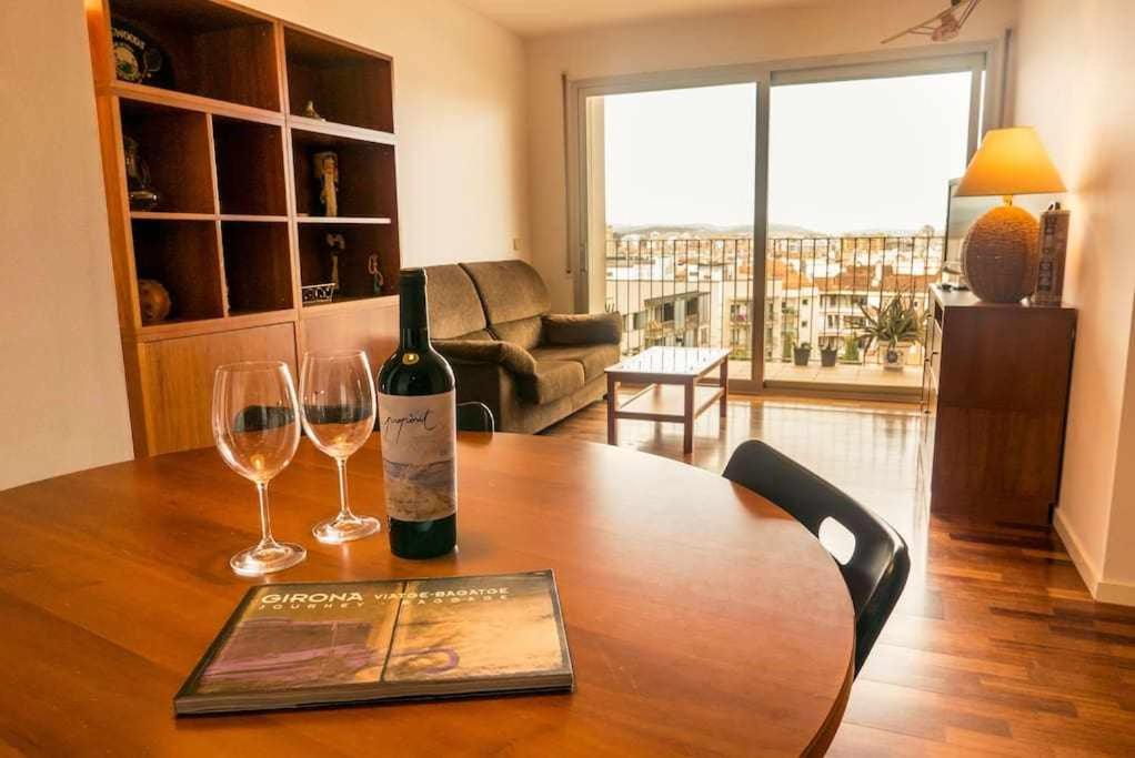 ジローナにあるApartamento con terraza y parking privado Gironaの木製テーブルにワイン1本とグラス2杯