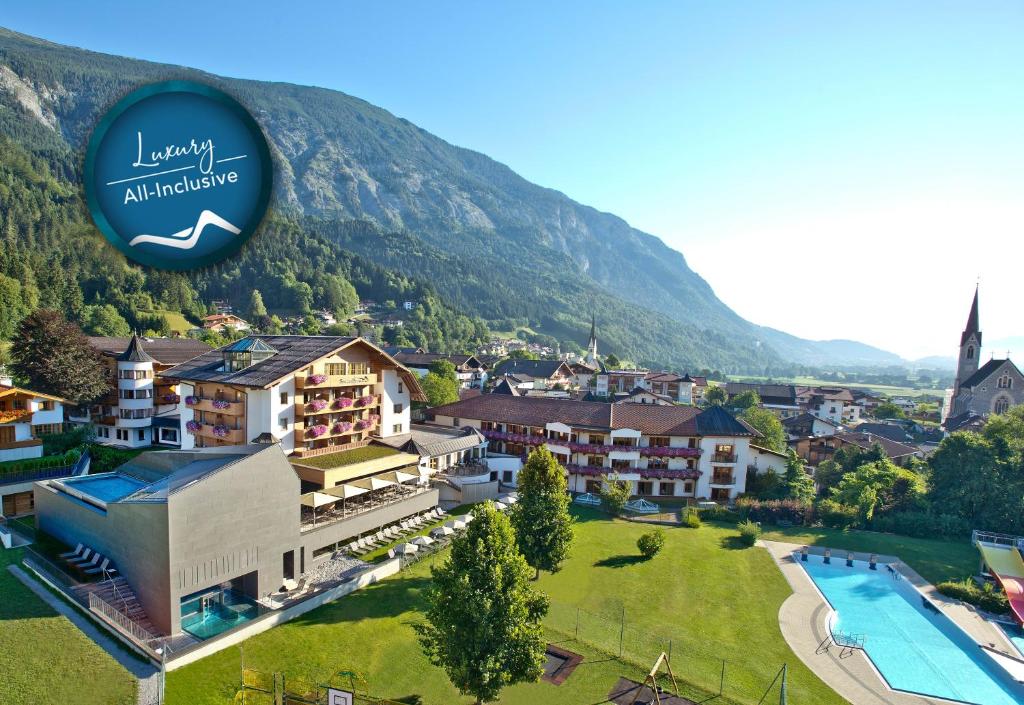 uma imagem de um resort com uma montanha ao fundo em All In Resort Schwarzbrunn - 4 Sterne Superior em Stans