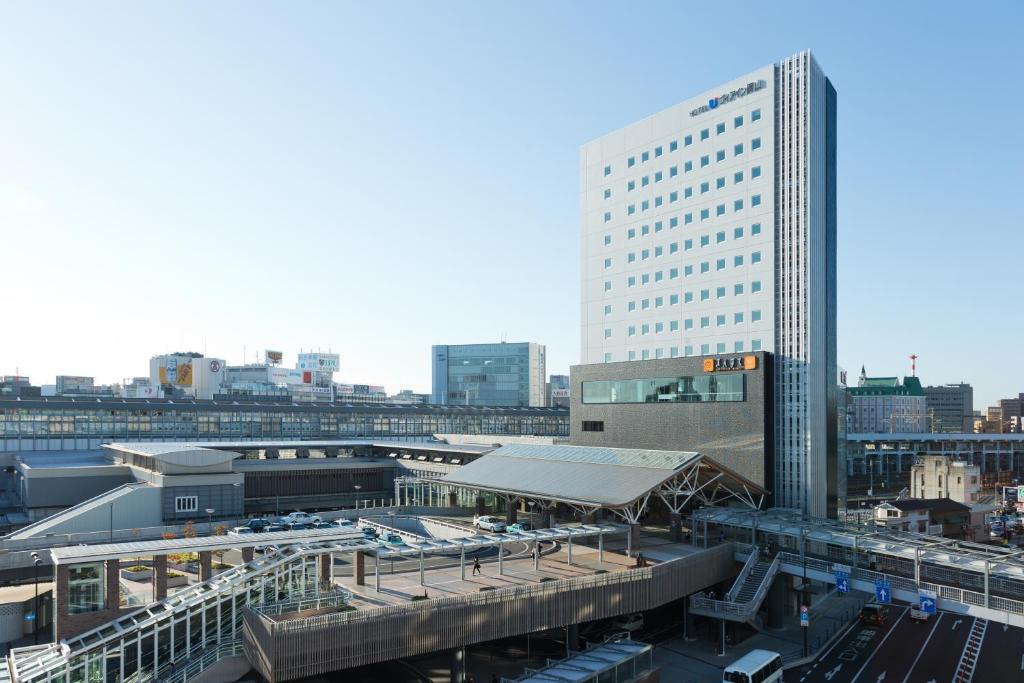 a city with a train station and a tall building at Via Inn Okayama in Okayama