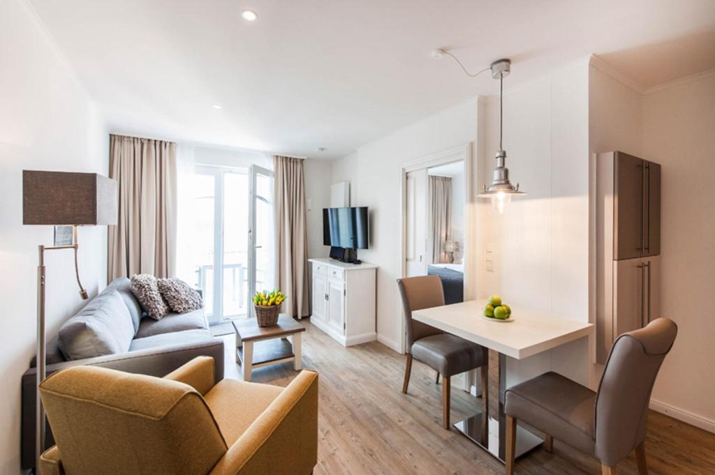 sala de estar con sofá y mesa en una habitación en Weisse Villa Apartment 2 4 Estelles Beachhouse en Büsum