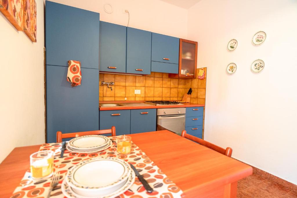 a kitchen with a wooden table and blue cabinets at [PIETRA LIGURE] The apartment for your vacations. in Pietra Ligure