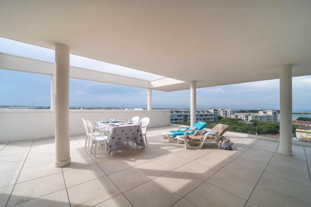 a balcony with a table and chairs and the ocean at Zero5.Zero5 in Lignano Sabbiadoro
