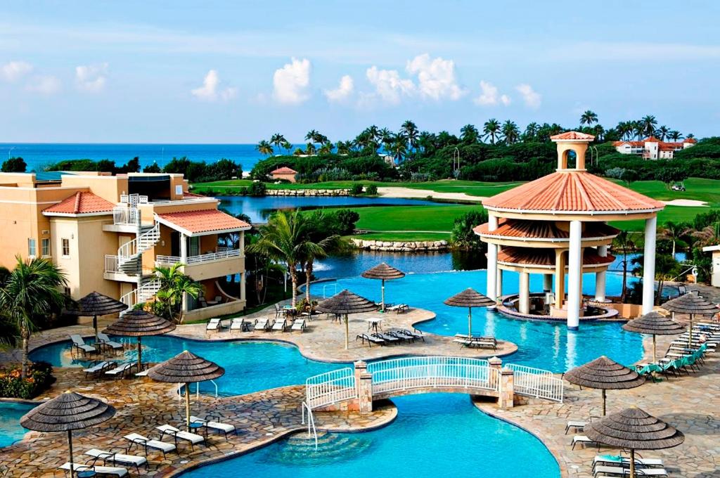 an aerial view of a resort with a pool and a gazebo at Divi Village Golf and Beach Resort in Palm-Eagle Beach