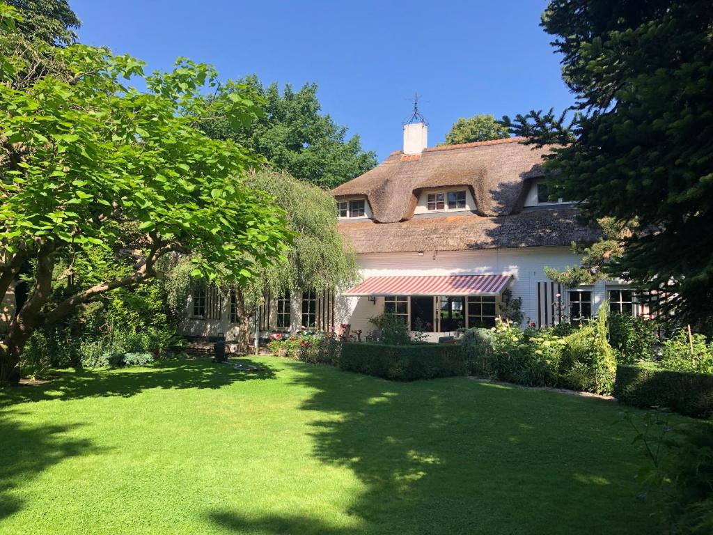 a house with a green lawn in front of it at Bed and Breakfast De Haen - Privé-appartementen van 43 of 60 m2 met tweepersoons bubbelbad - Finse sauna - in westvleugel van luxe villa in Oss