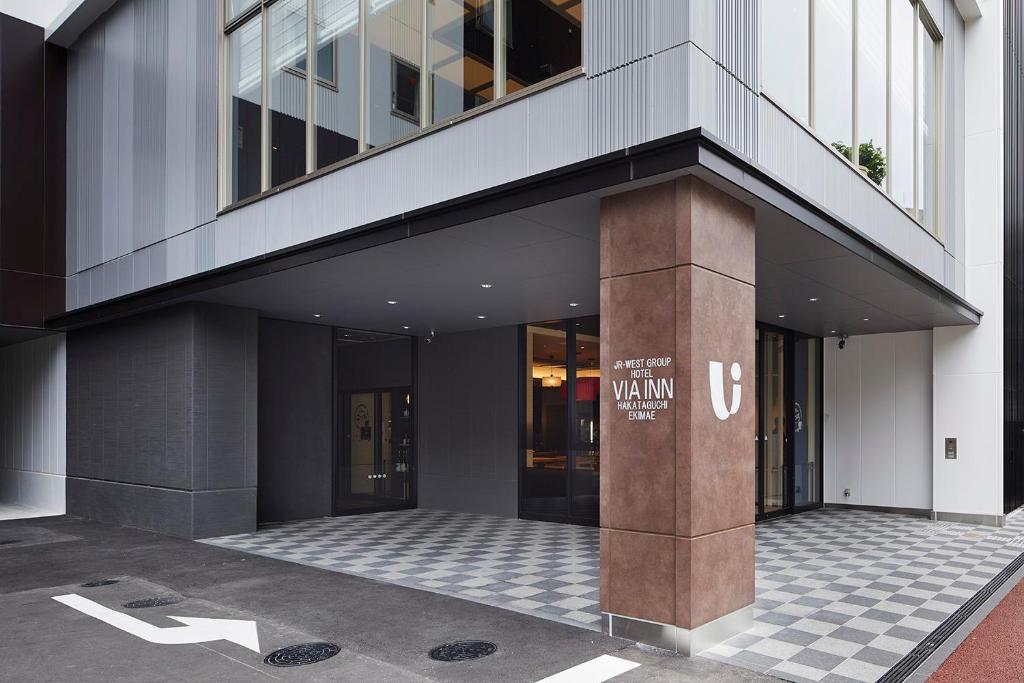 a building with a column with a sign on it at Via Inn Hakataguchi Ekimae in Fukuoka