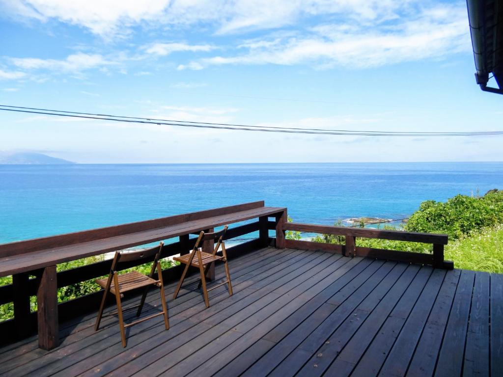 a bench on a deck with a view of the ocean at 一棟貸　屋久の子の家 in Yakushima