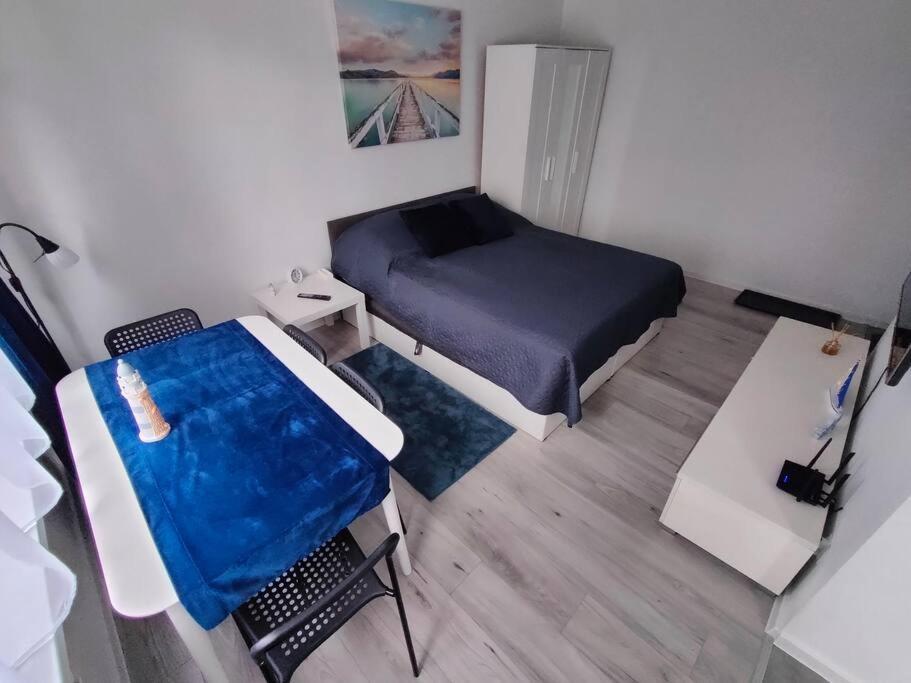 mały pokój z łóżkiem i stołem w obiekcie Przystań Sandomierz w mieście Sandomierz