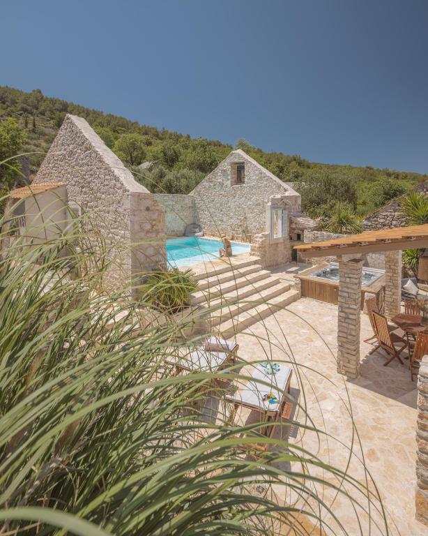 a stone house with a swimming pool and a patio at Casa M Hvar in Zastražišće
