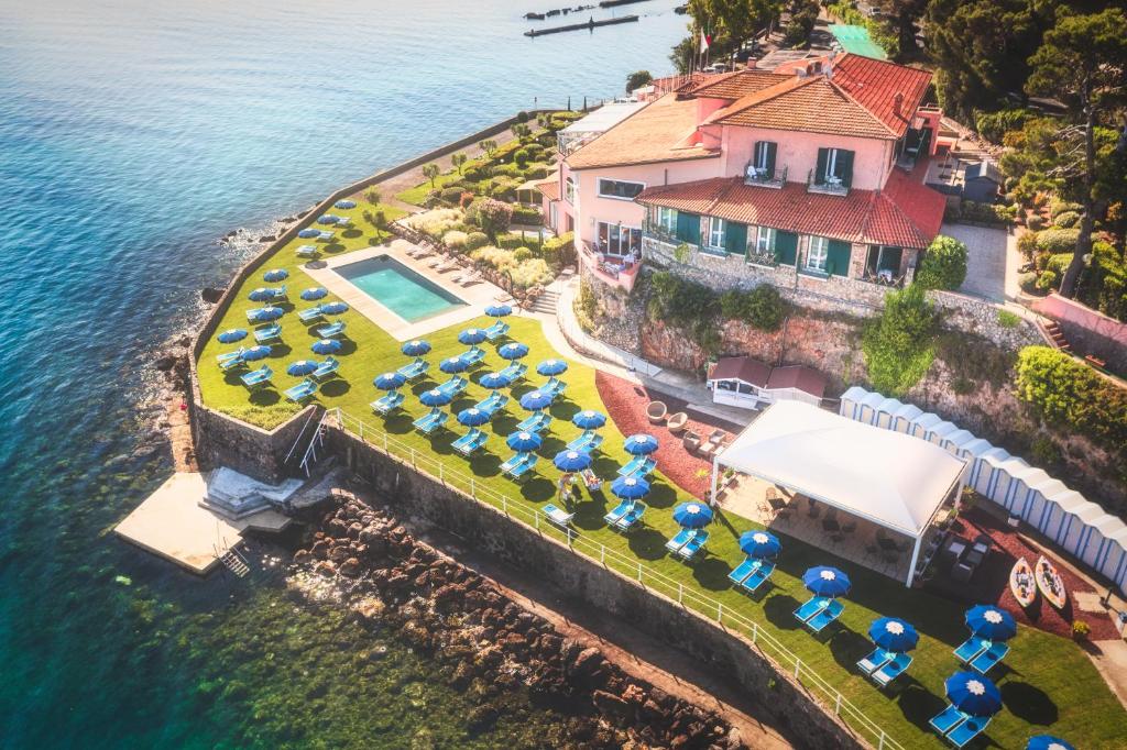 uma vista aérea de um resort com cadeiras e guarda-sóis em Hotel Villa Domizia em Porto Santo Stefano