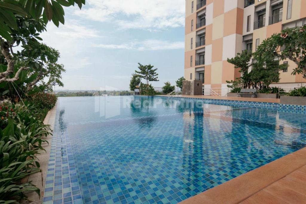una piscina al centro di un edificio di Redliving Apartemen Sayana - Hazelnut Property Tower Cha a Penggarutan