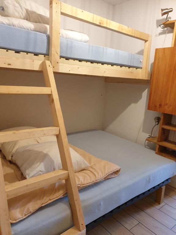 梅里貝勒的住宿－Résidence Alpinéa Mottaret, 3 à 5pers，带梯子的客房内的两张双层床