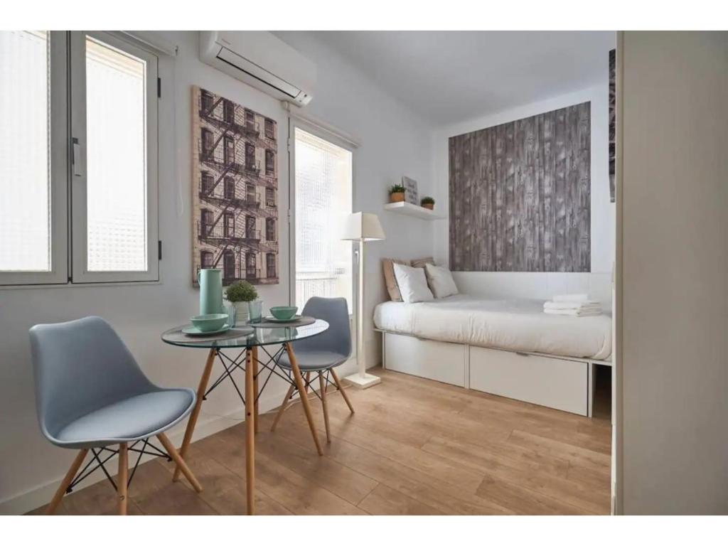 a bedroom with a bed and a table and chairs at Retiro Park Apartments in Madrid