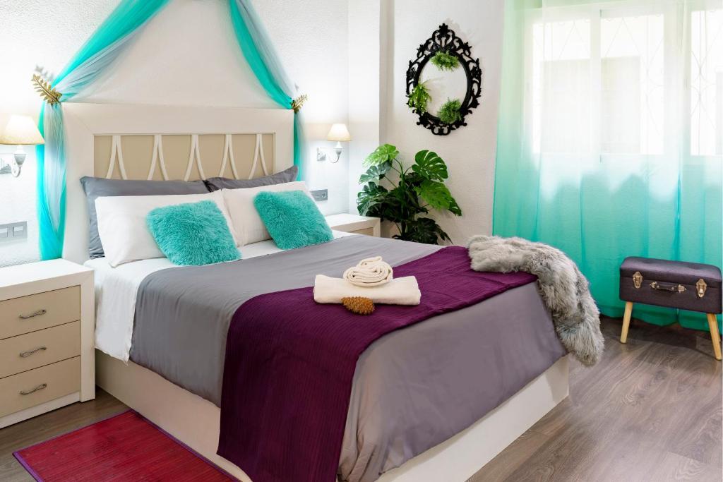 1 dormitorio con 1 cama grande con almohadas azules en My Granada Garden - Mimosa studio, en Granada
