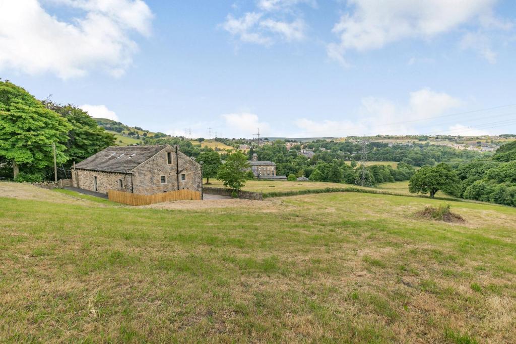 an old house in a field of grass at Top Barn in Sowerby Bridge