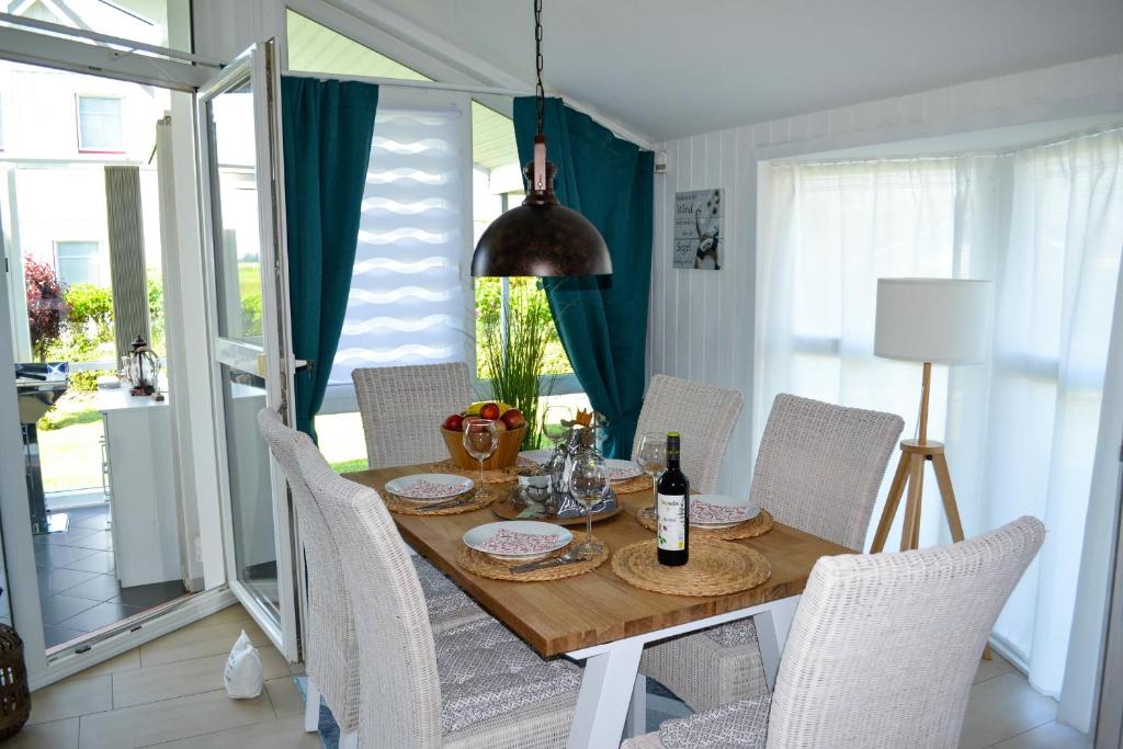 een eetkamer met een tafel met stoelen en een tafel bij Modernes Ferienhaus direkt an der Nordsee in Wesselburenerkoog
