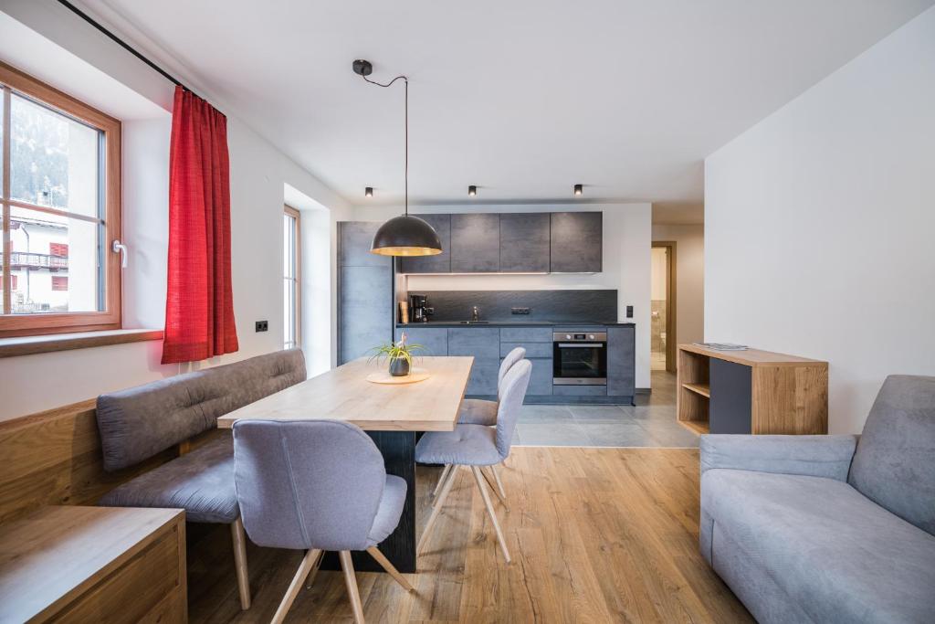 uma cozinha e sala de estar com uma mesa e um sofá em Kuenz Dolomites App 3 em San Candido