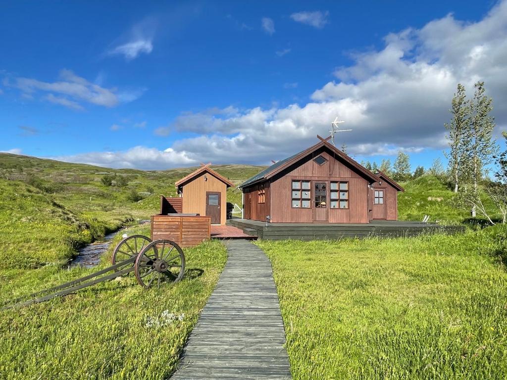 een houten pad naar een huis in een veld bij Dalsmynni in Blaskogabyggd