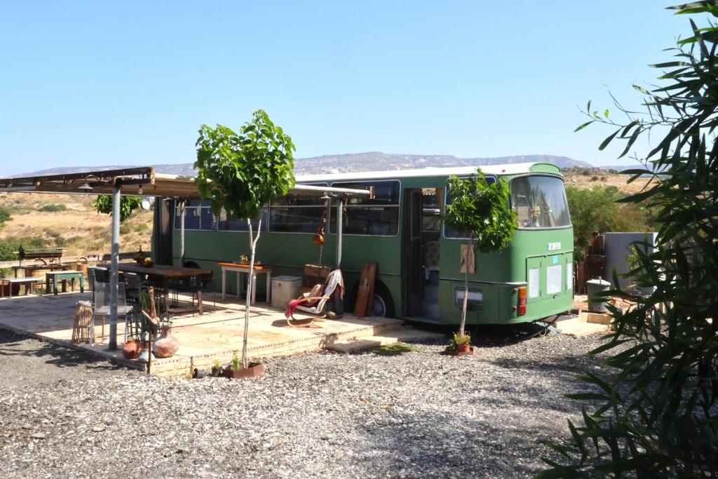 un autobús verde estacionado frente a un edificio en Green Bus unique & private 3 min from Coral Bay, en Akoursos