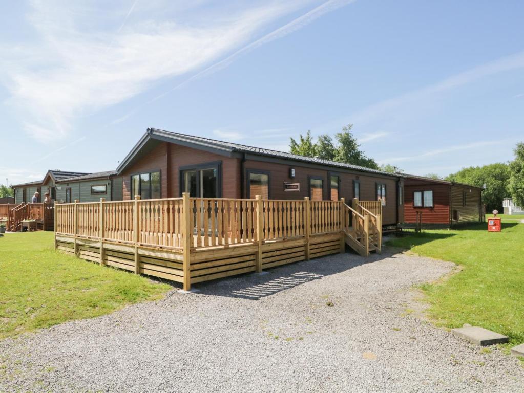 ein großes Holzhaus mit einer großen Terrasse in der Unterkunft Parkers Place in Carnforth