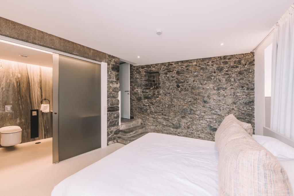 een slaapkamer met een stenen muur en een bed bij Torrinha Garten Apartment in Funchal