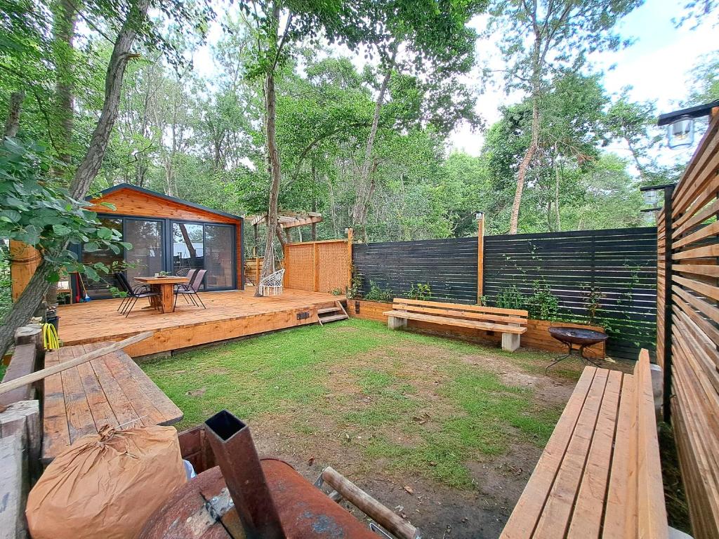 un patio trasero con bancos, una mesa de picnic y una valla en Vista Cottage 2 en Ulcinj