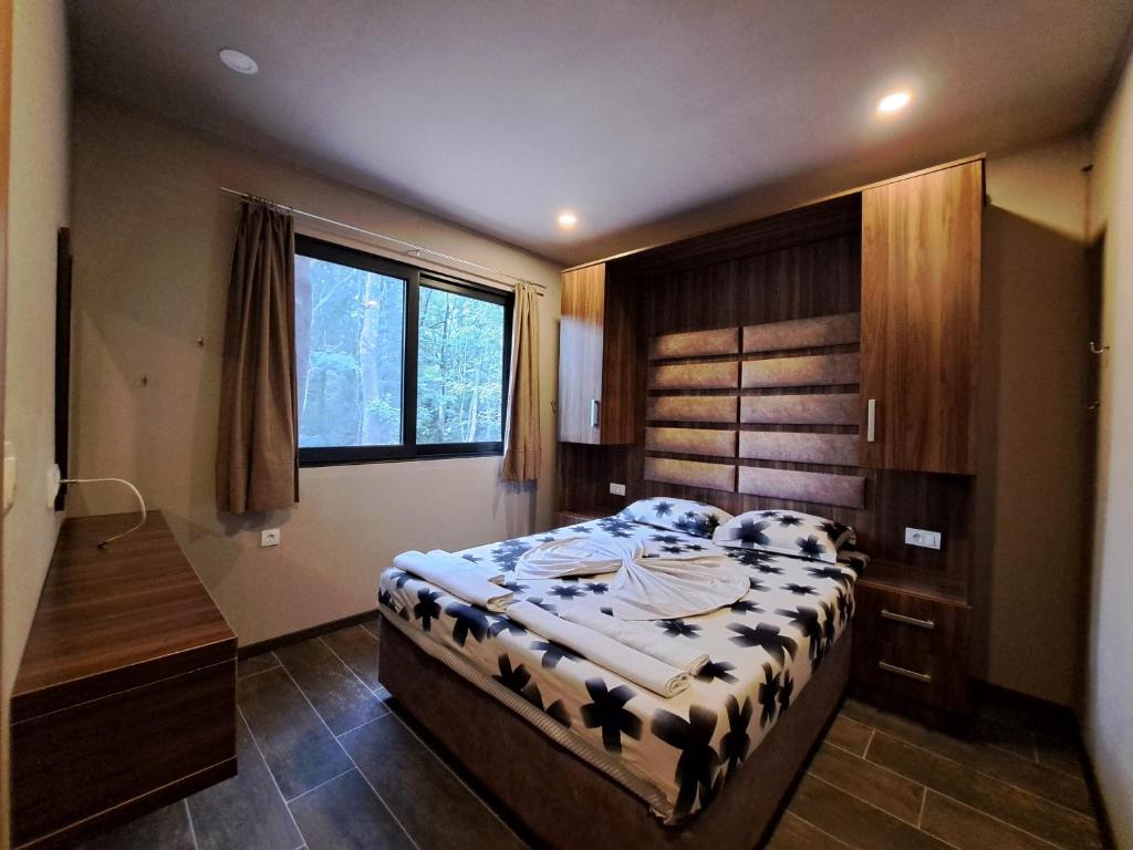 a bedroom with a bed and a desk and a window at Vista Cottage 2 in Ulcinj
