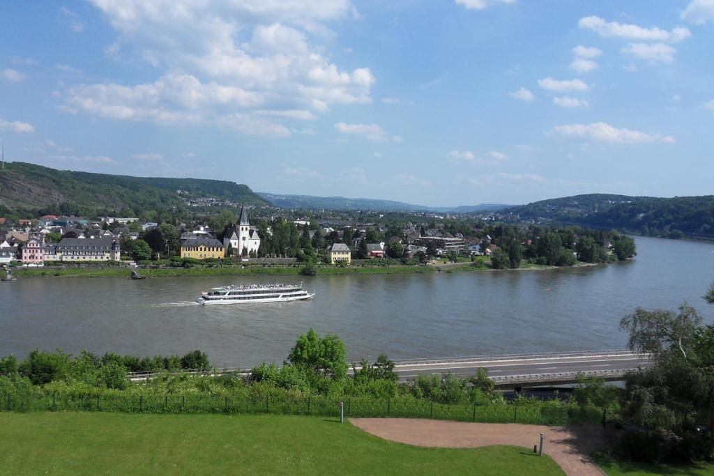 a boat on a river with a town in the background at Ringhotel Haus Oberwinter in Remagen