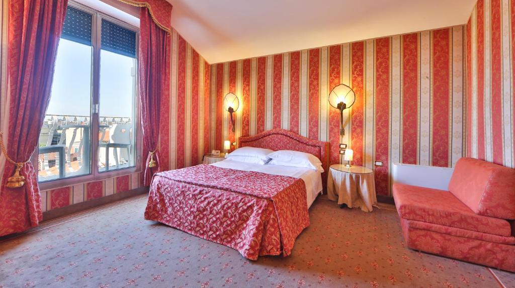 a hotel room with a bed and a couch at Hotel Biasutti in Venice-Lido