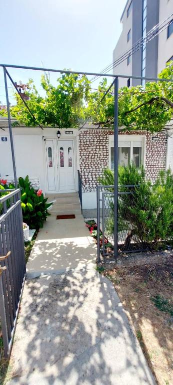 a walkway leading to a house with a white door at Apartments Radulovic in Sutomore