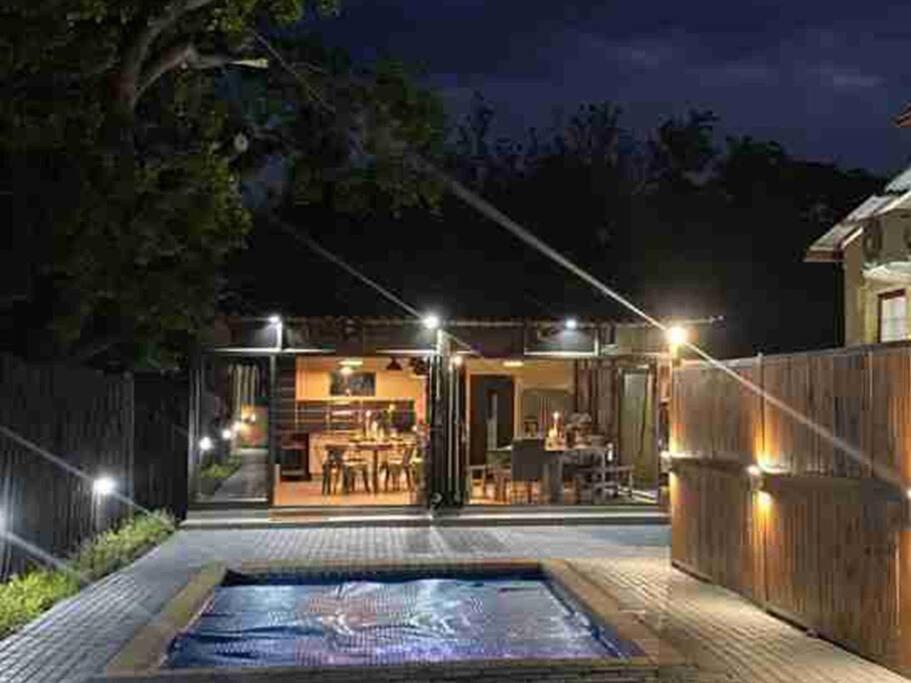 un patio trasero con piscina por la noche en 74 on retief Guesthouse, en Potchefstroom