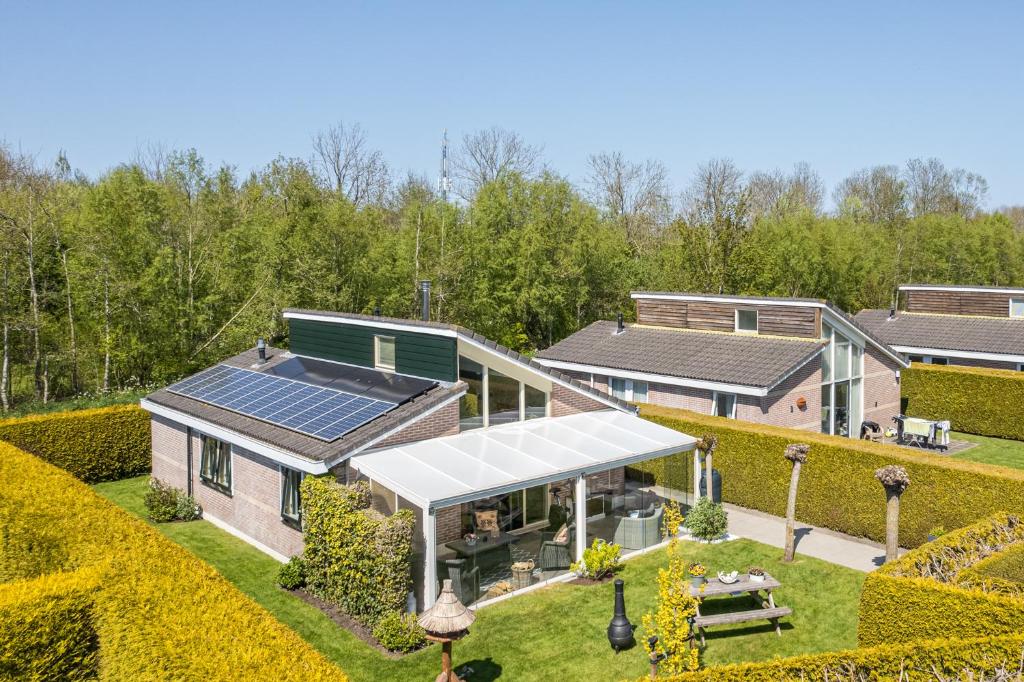 een luchtzicht op een huis met zonnepanelen op het dak bij Vakantiewoning met serre en airconditioning in Tzummarum