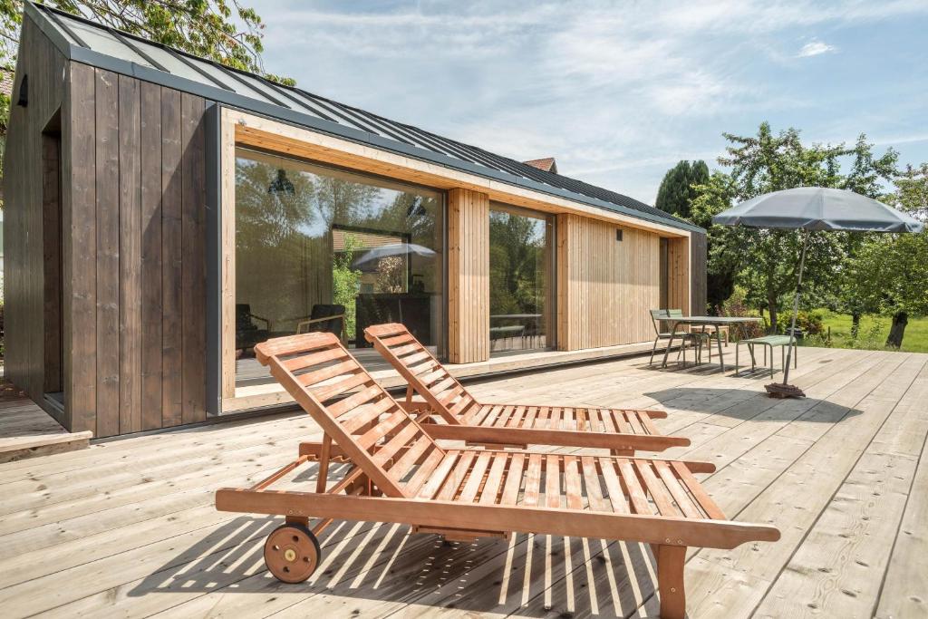 - une terrasse avec 2 chaises et un parasol dans l'établissement Tiny House Lachen, à Wangen im Allgäu