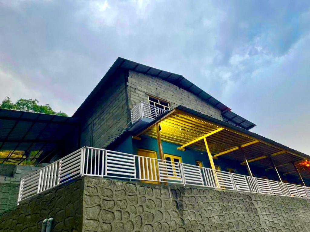 een gebouw met een balkon erboven bij Mrig Valley Resort, Homestay & Banquet in Kandikhal