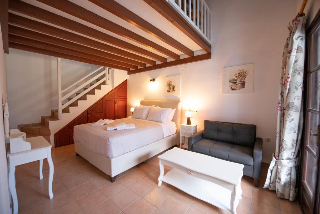 a bedroom with a bed and a couch and a staircase at Hovolo Hotel Apartments in Neo Klima