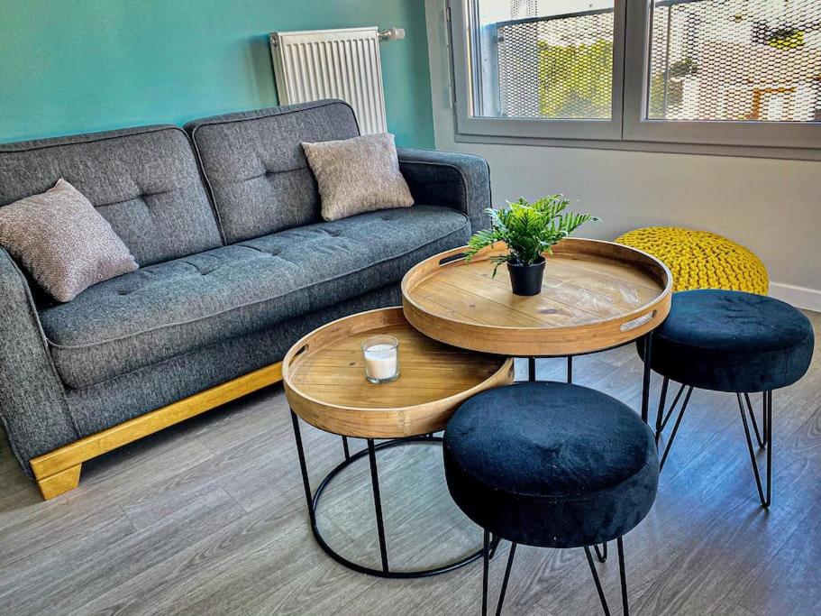 ein Wohnzimmer mit einem Sofa und 2 Tischen in der Unterkunft Charmant T2 lumineux au pied de la gare in Courcouronnes
