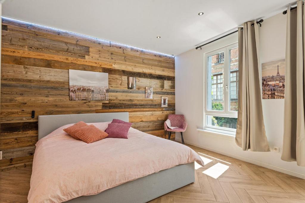 a bedroom with a wooden accent wall and a bed at Suite city center in quiet street & airco in Antwerp
