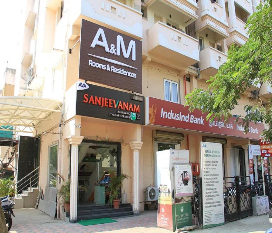 a store front of a building with signs on it at A and M Rooms and Residences in Chennai