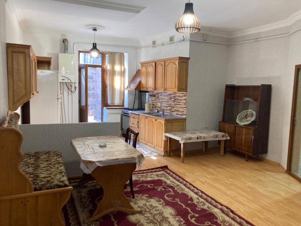 a living room with a table and a kitchen at Gyumri house in Gyumri