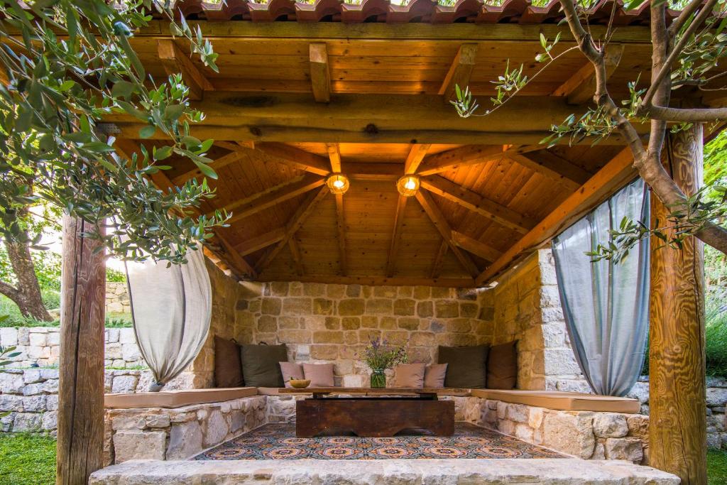 eine Außenterrasse mit einem Tisch und einer Steinmauer in der Unterkunft Holiday Home Radic in Klis