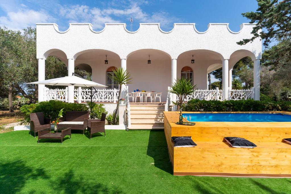 een achtertuin met een zwembad en een huis bij Villa Garden Rose by BarbarHouse in Porto Cesareo