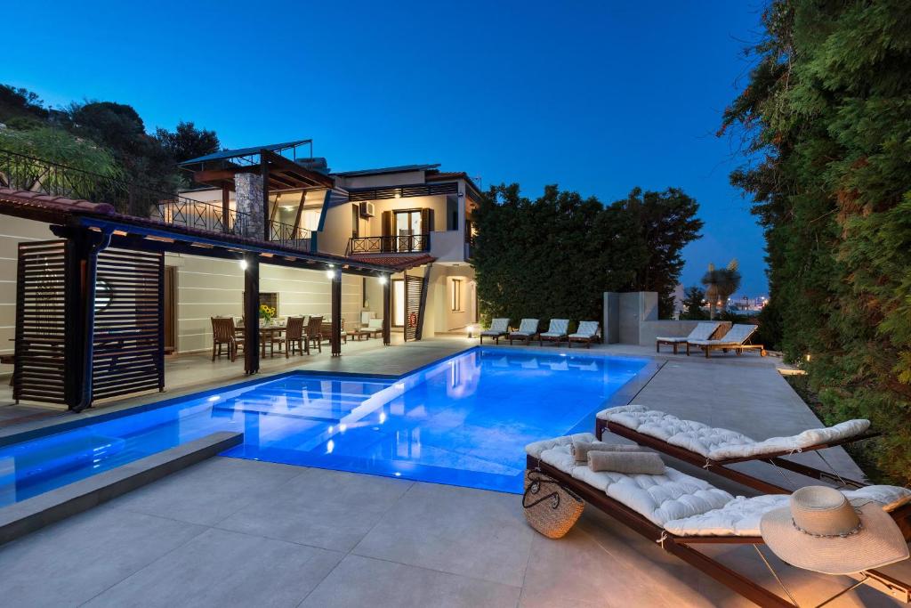 a swimming pool in front of a house at 3 Roses Residence in Afantou